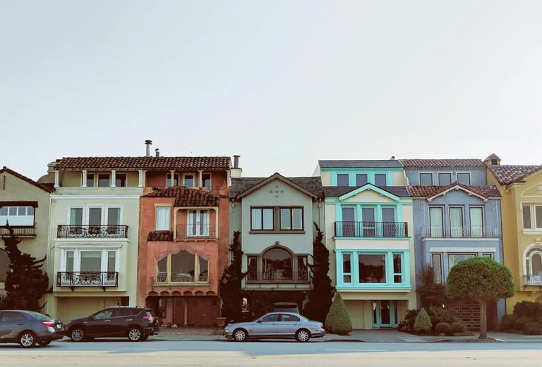 Row of colorful two-story houses along a residential street